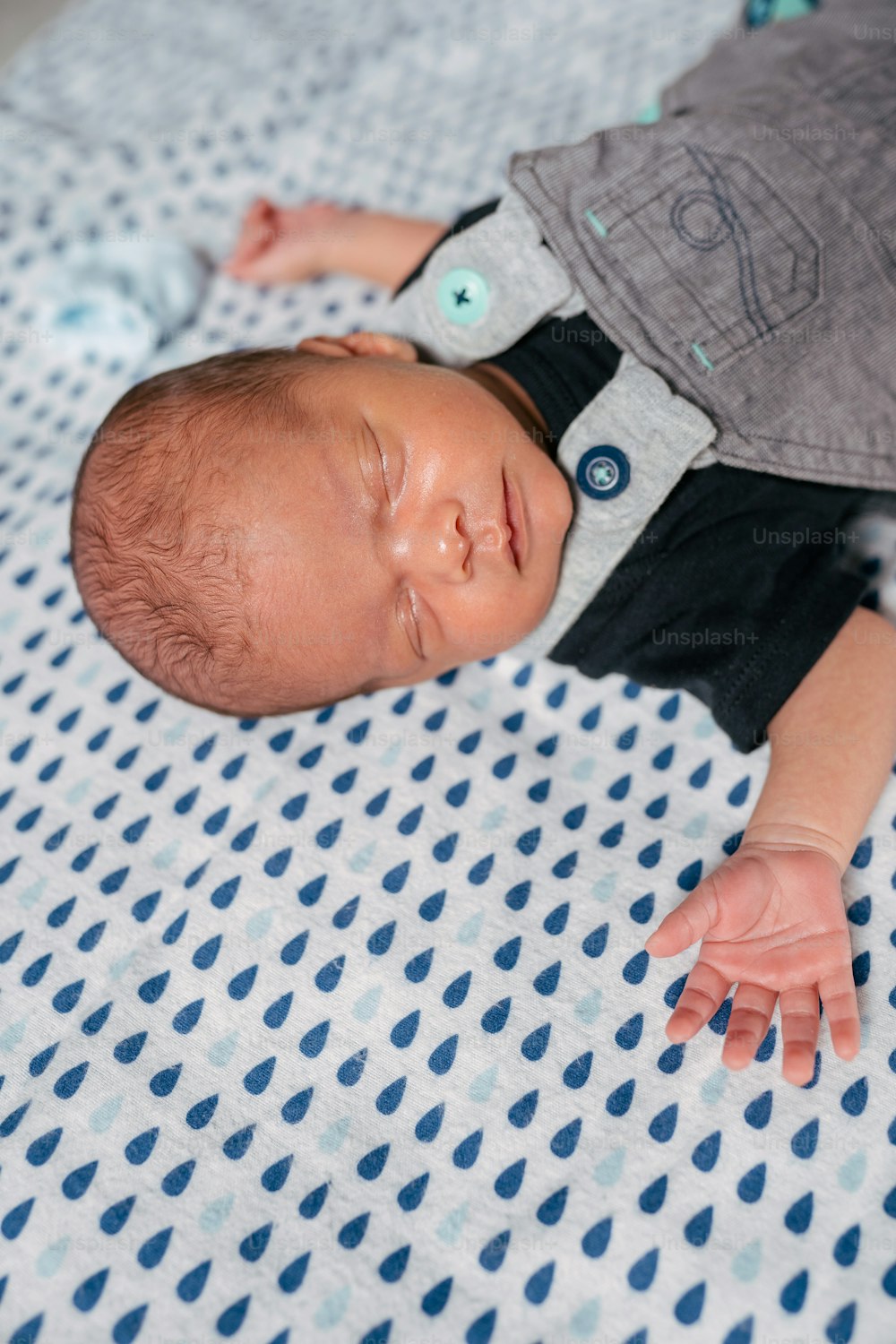 a baby laying on top of a blue and white blanket