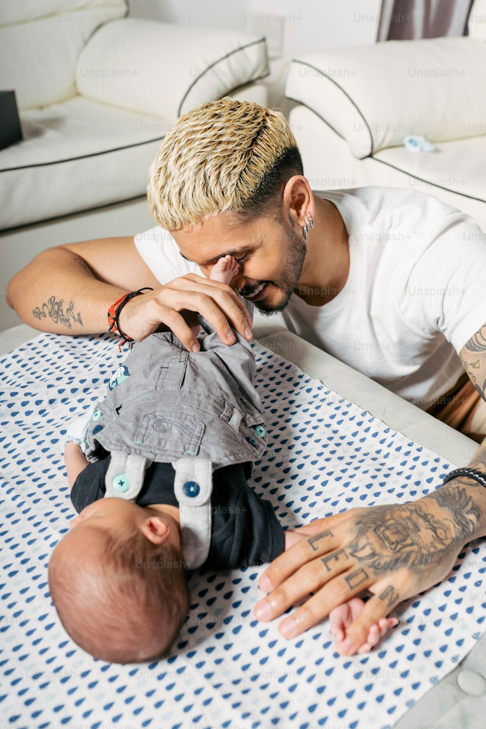 a man holding a baby on top of a bed