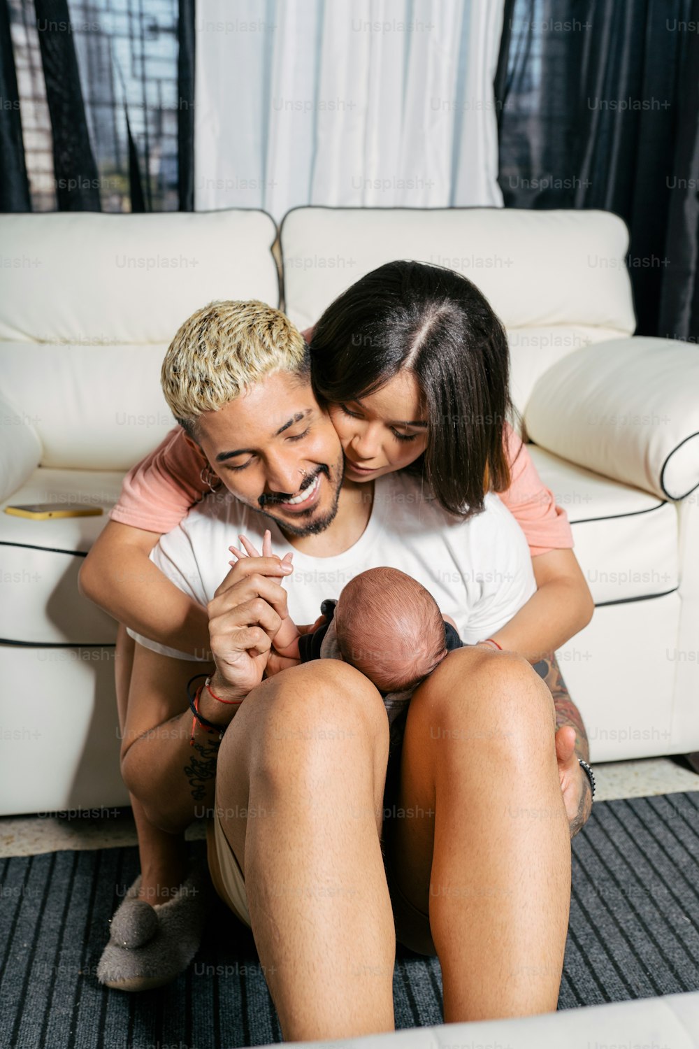 a man and woman sitting on a couch holding a baby