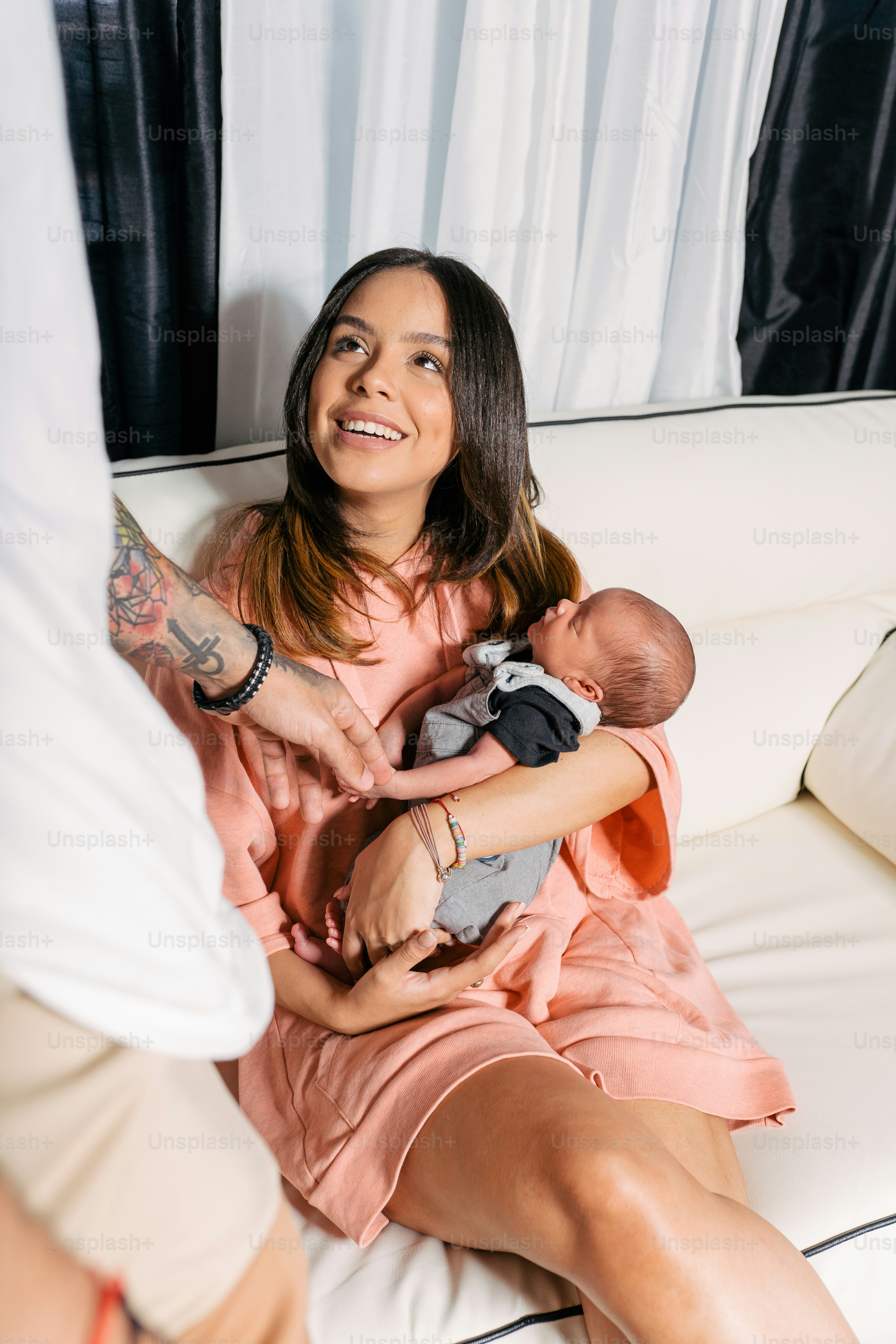 a woman sitting on a couch holding a baby