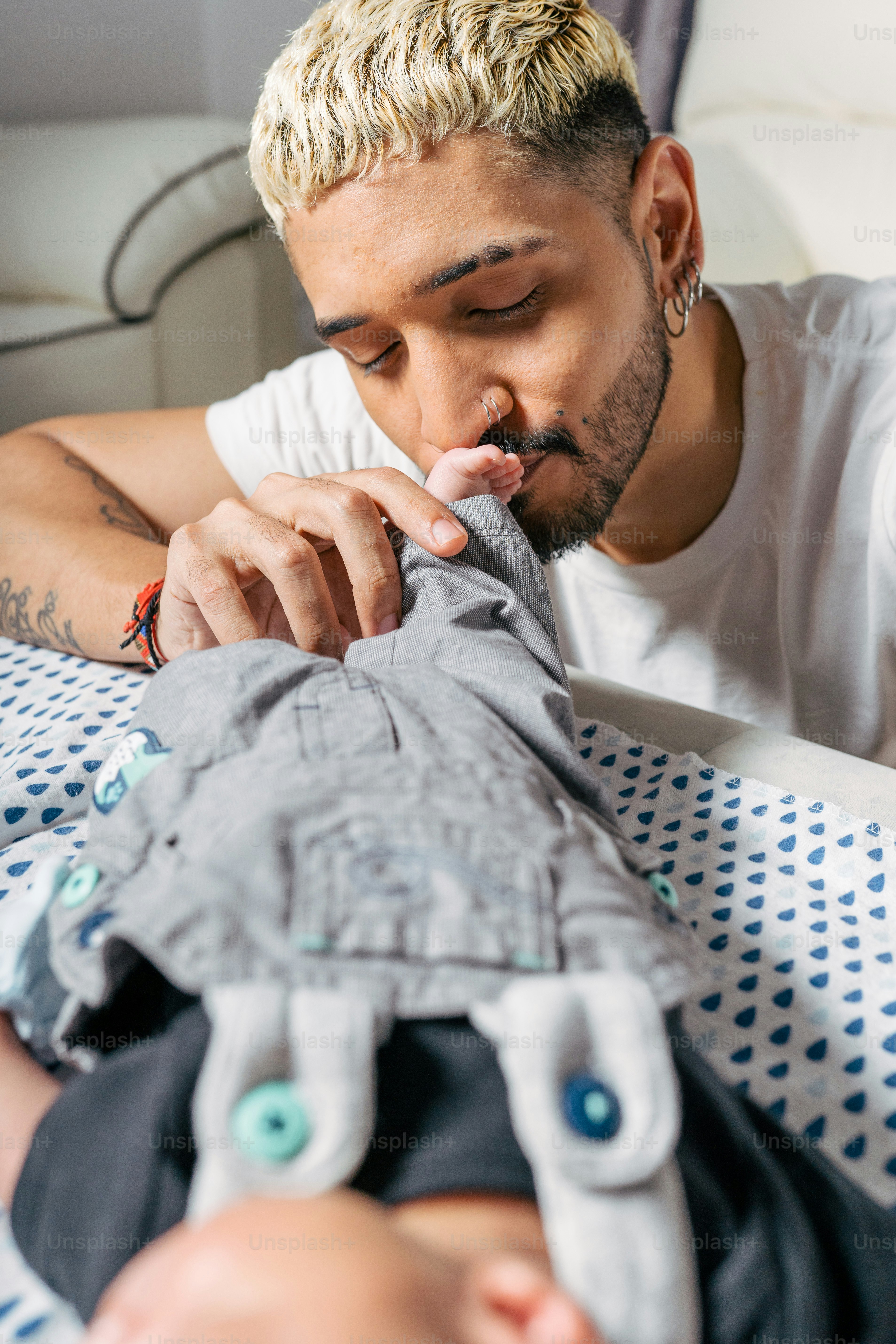 Un homme allongé dans son lit avec un bébé sur ses genoux