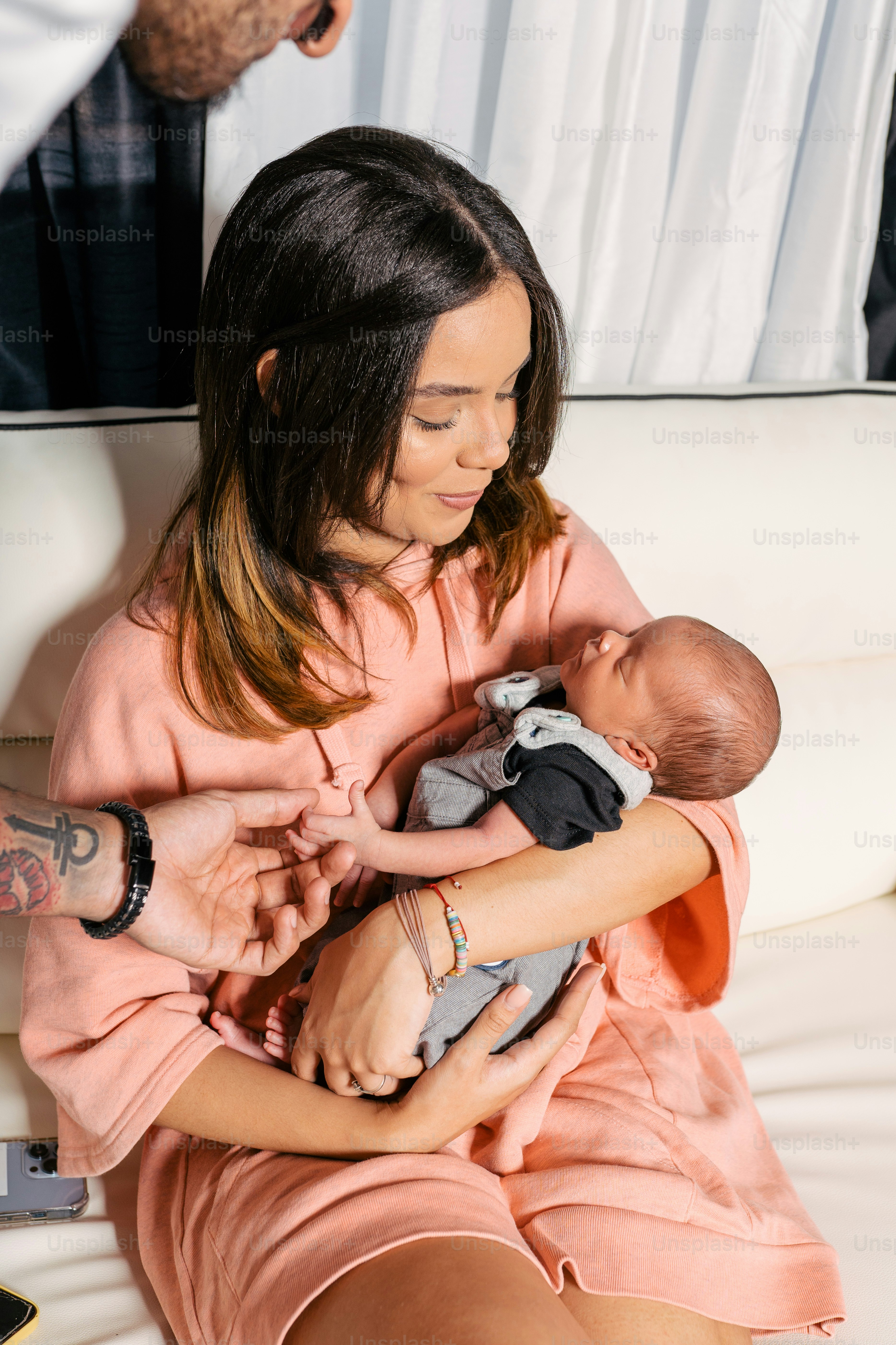 une femme tenant un bébé assise sur un canapé