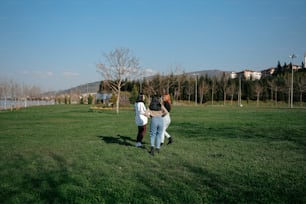 a group of people standing on top of a lush green field