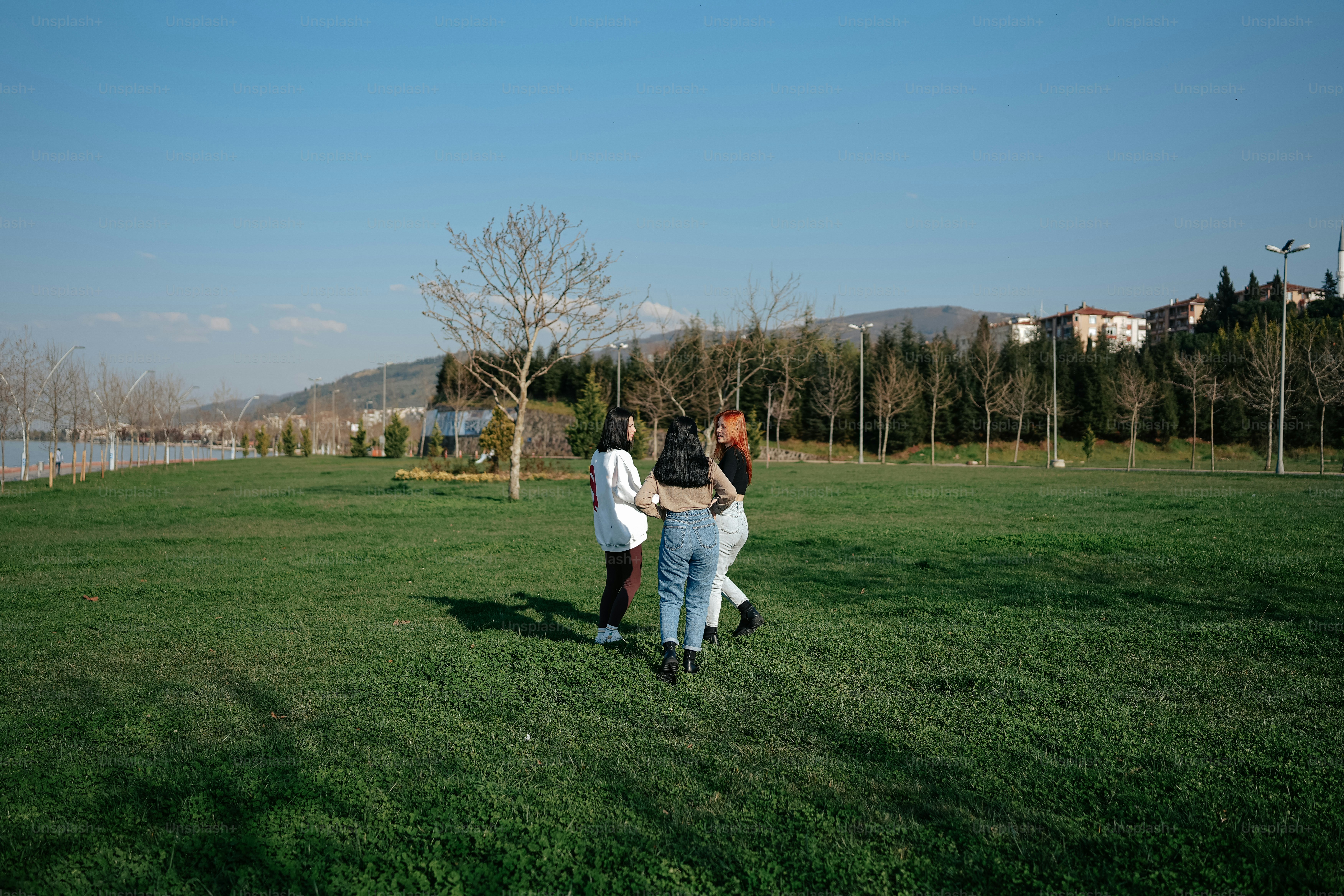 a group of people standing on top of a lush green field