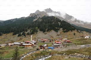 uma pequena aldeia nas montanhas com uma montanha ao fundo
