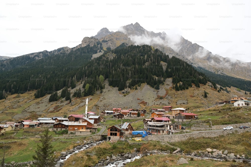 Un pequeño pueblo en las montañas con una montaña al fondo