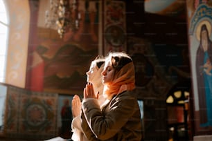 uma mulher está orando em uma igreja
