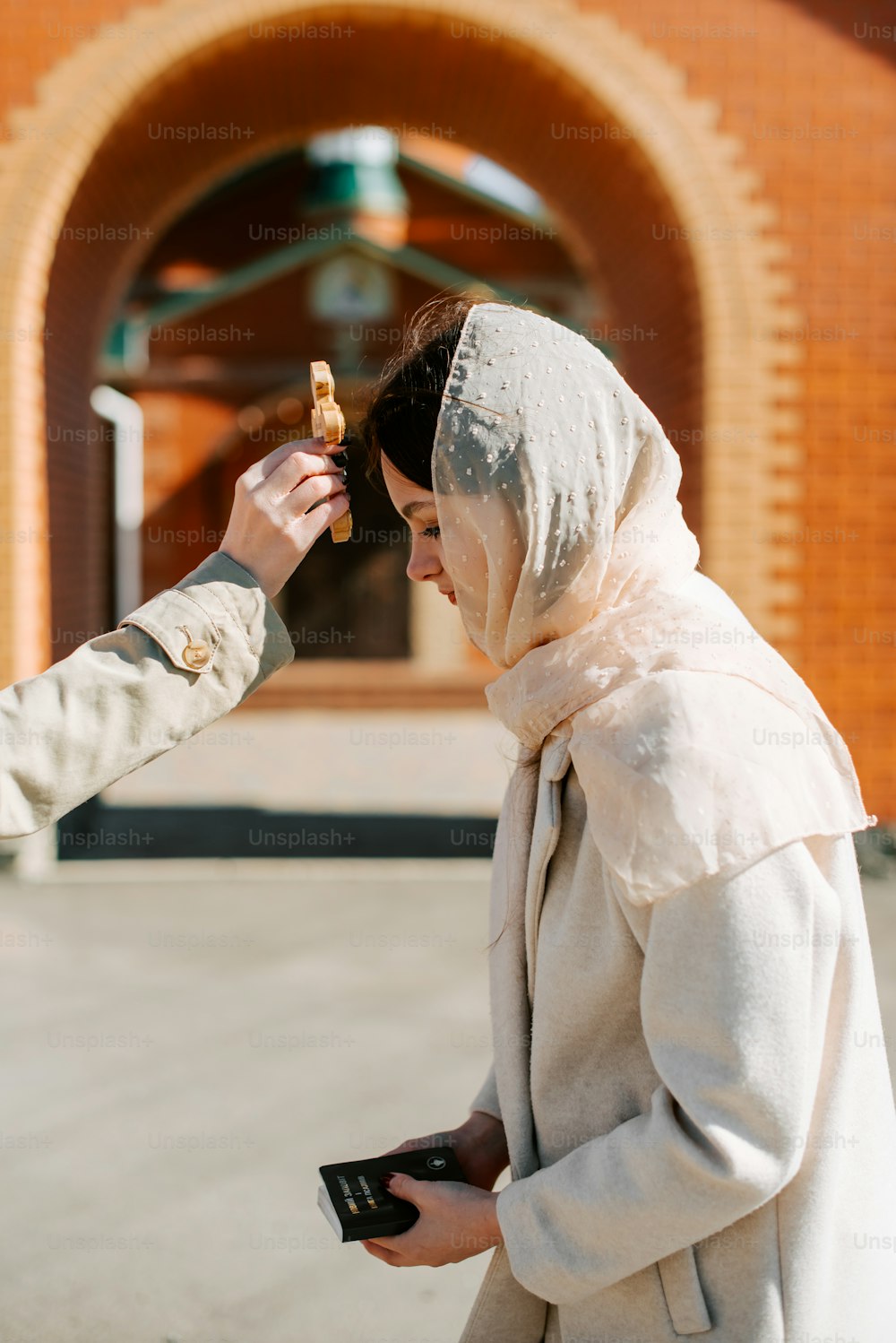 a woman in a veil is holding a cell phone