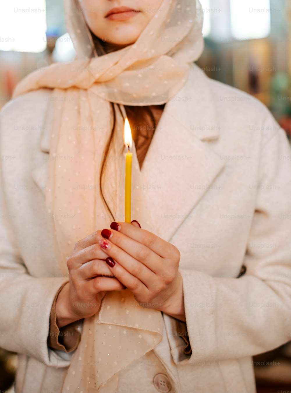 Una mujer sosteniendo una vela en sus manos