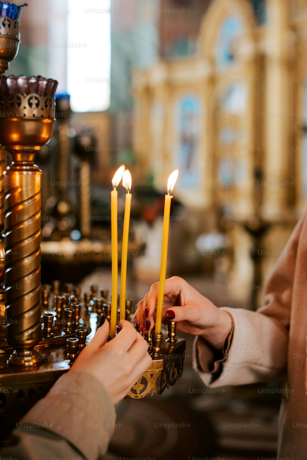 a woman lighting candles in a church