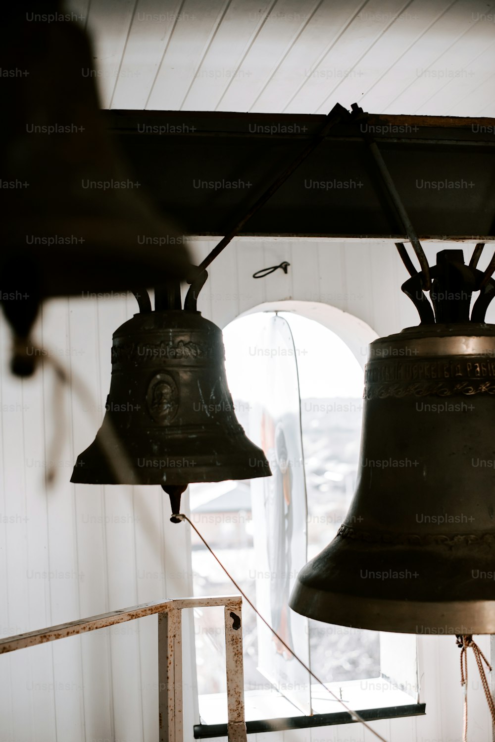 two bells hanging from a ceiling in a room