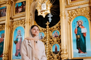 a woman standing in front of a golden alter