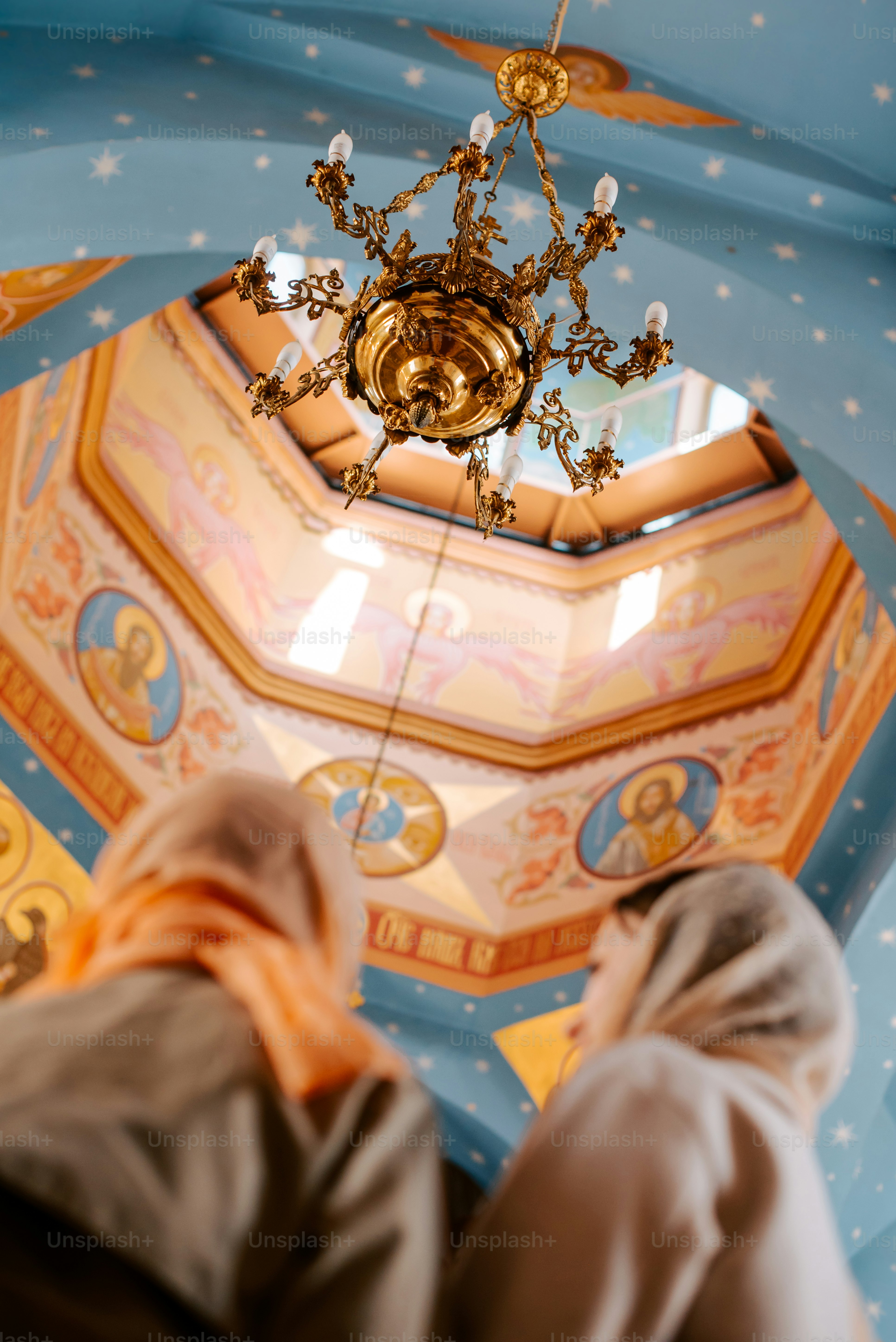 a couple of people standing under a chandelier