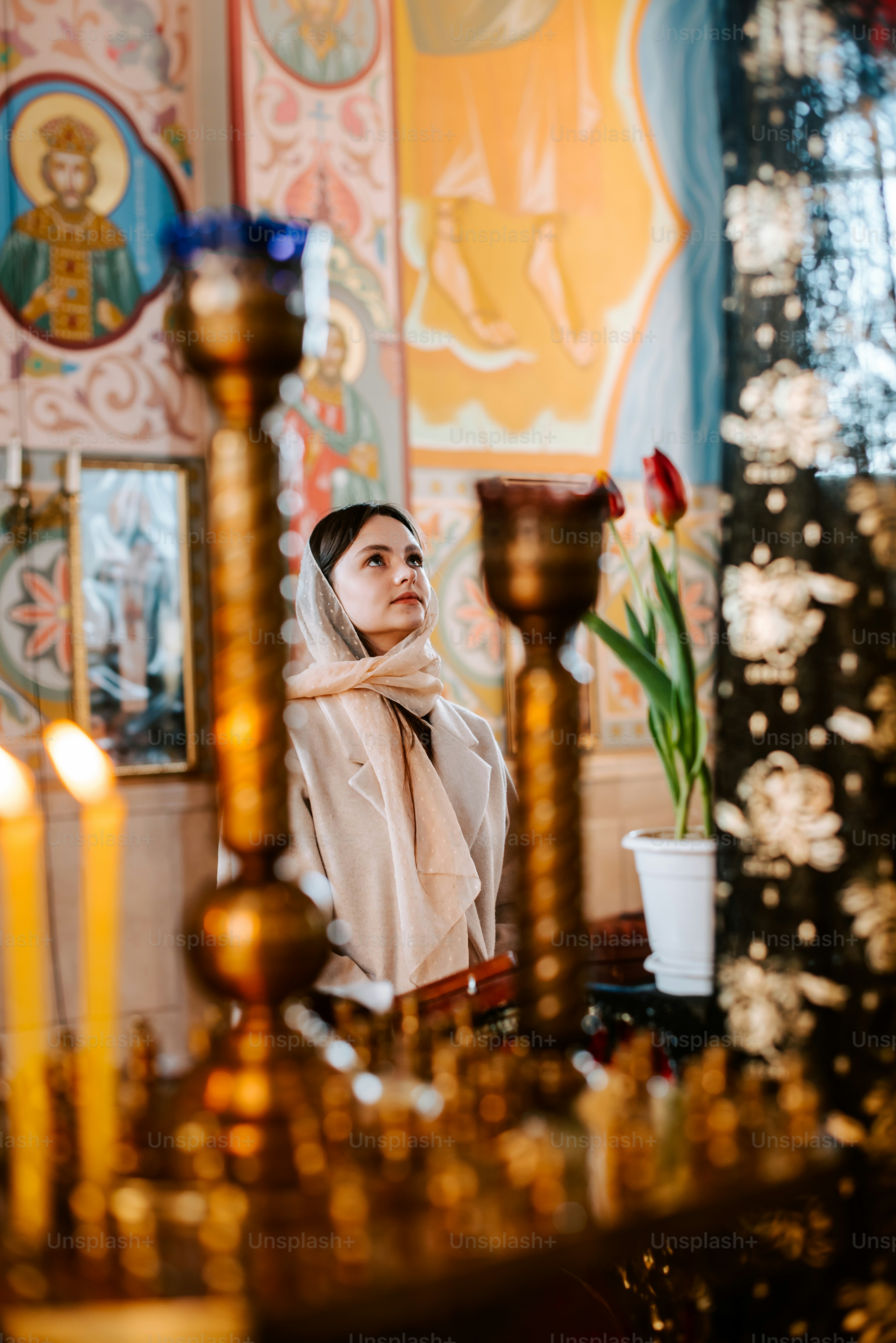a woman wearing a veil standing in a room with candles