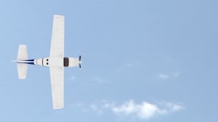 a small airplane flying through a blue sky