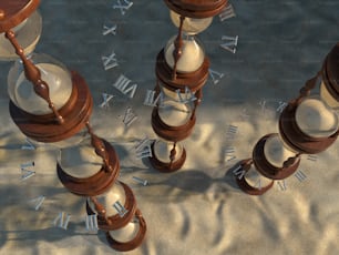 a group of clocks sitting on top of a sandy beach