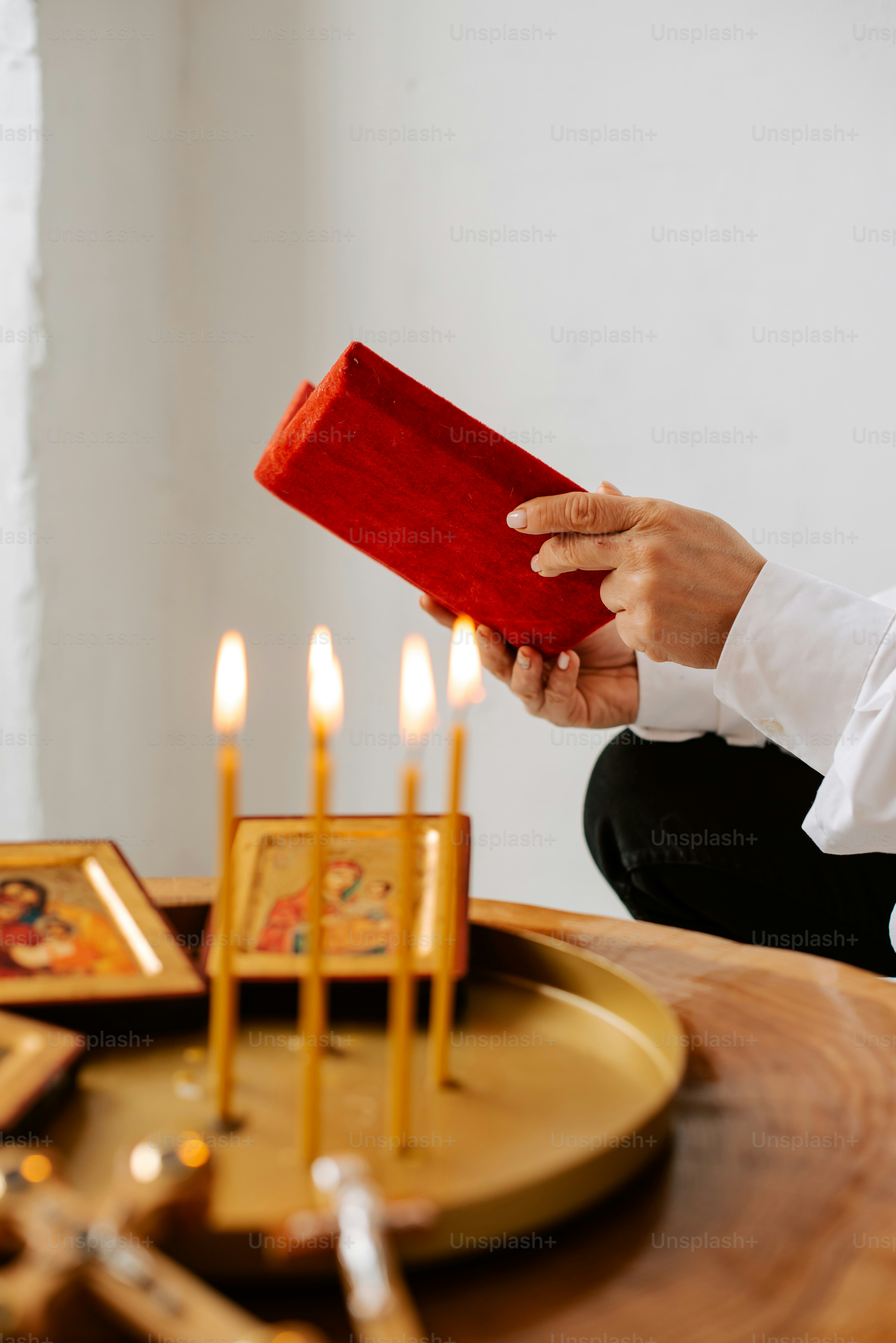 a person sitting at a table with a red cloth
