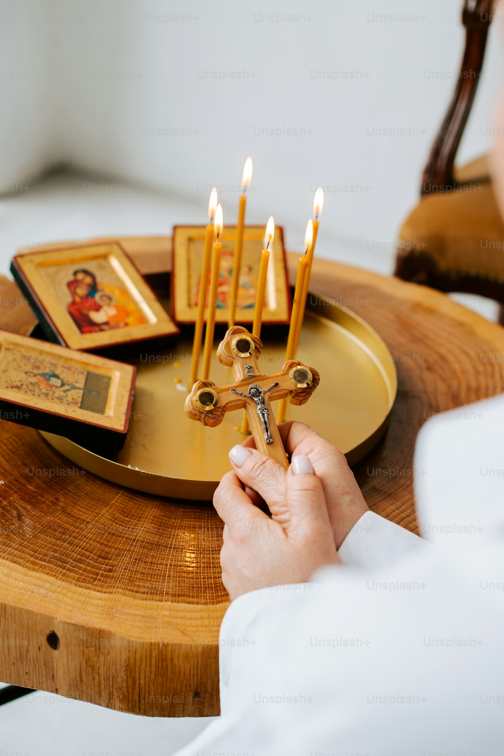 eine Person, die Kerzen auf einem Holztisch anzündet