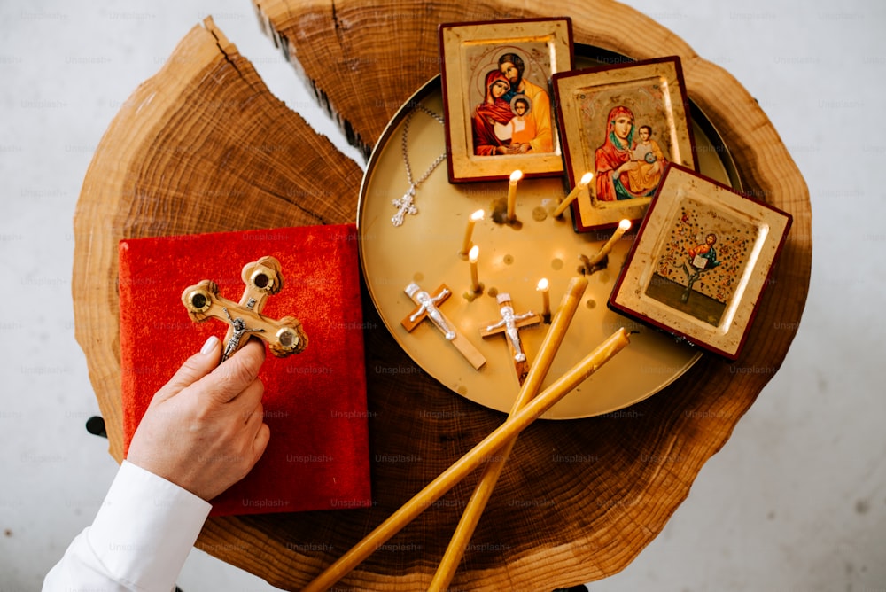 a person holding a cross on top of a wooden table