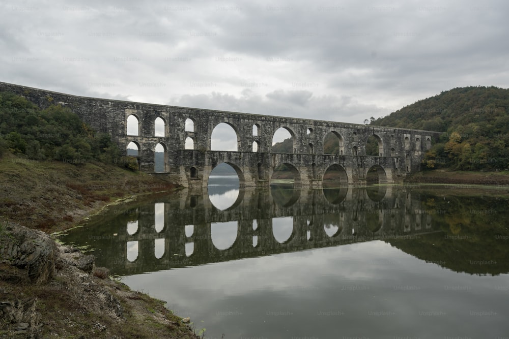 un grand pont de pierre au-dessus d’un plan d’eau