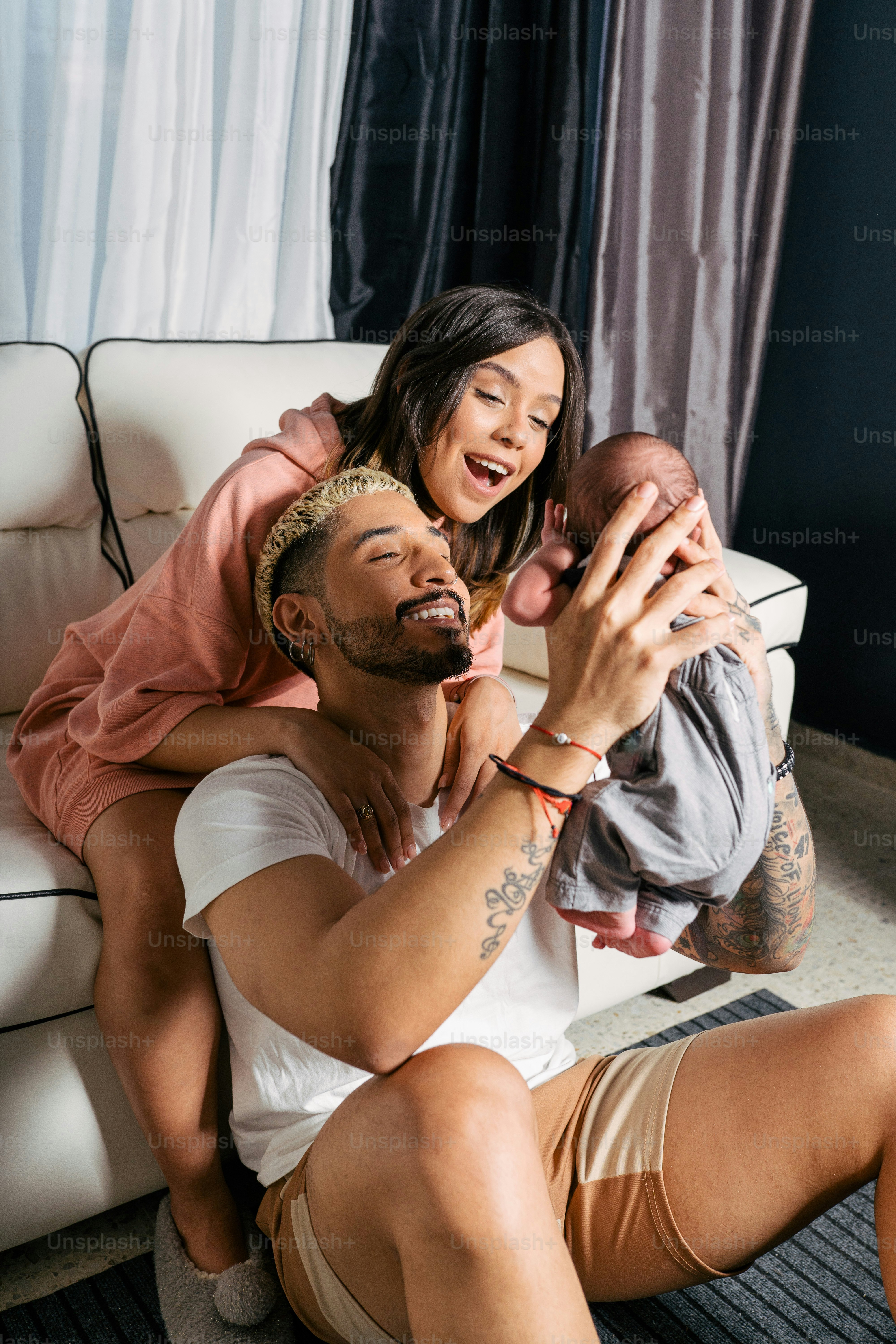 a man holding a baby while sitting on a couch