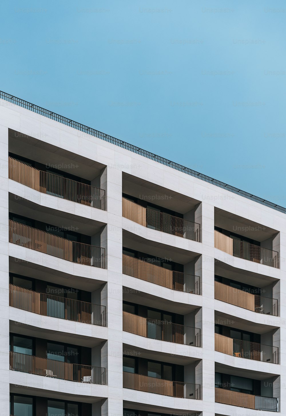 a tall white building with balconies and balconies