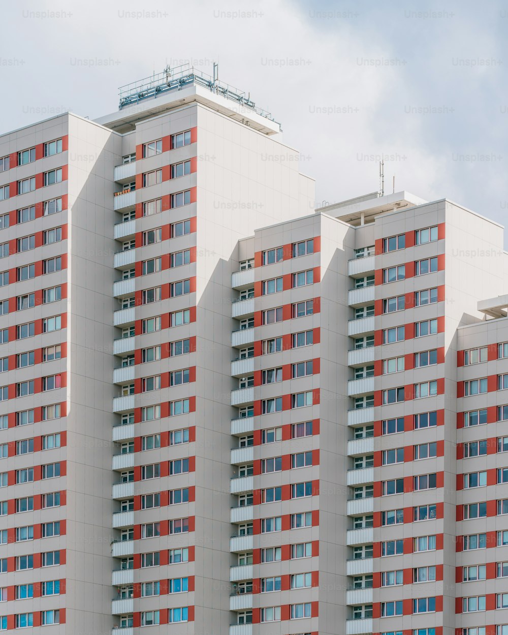 Ein hohes weißes Gebäude mit roten und blauen Fenstern