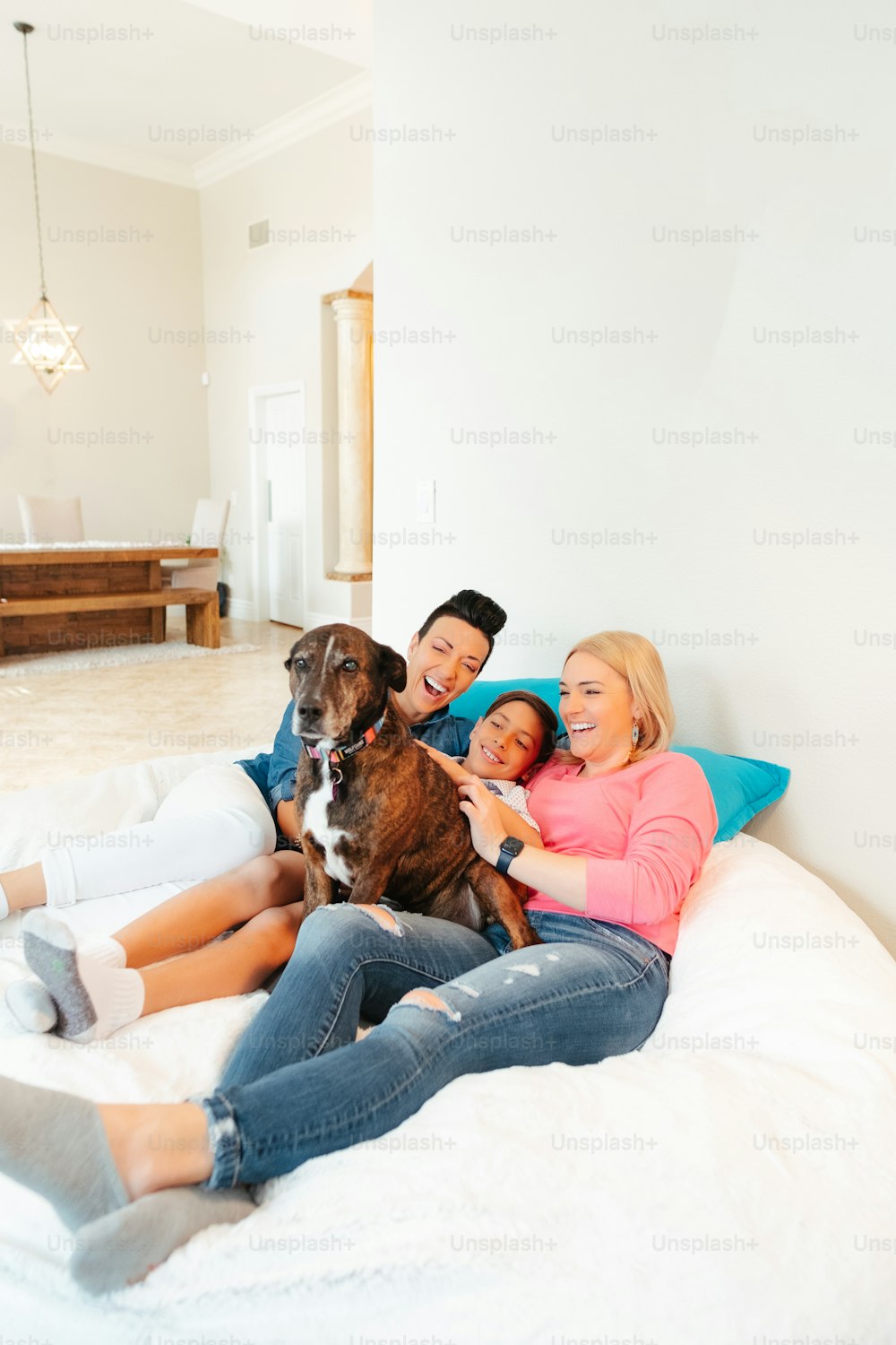a group of people sitting on a bed with a dog