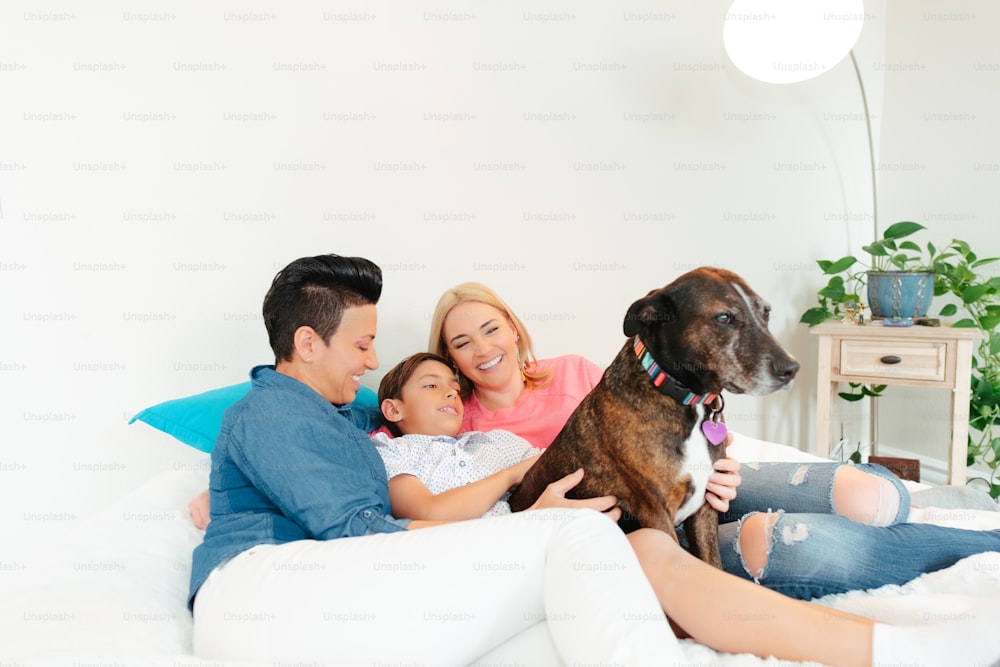 a family sitting on a bed with a dog