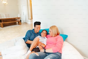 a man and woman sitting on a couch with a baby