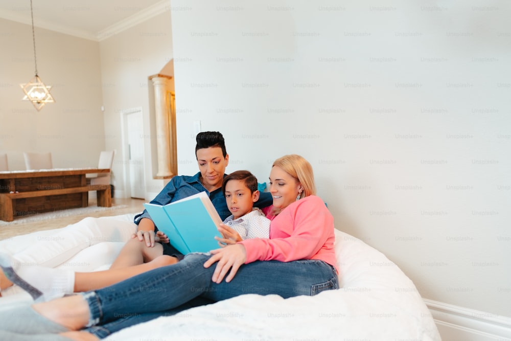 a family sitting on a bed reading a book