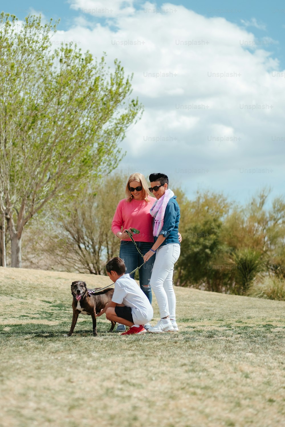 un homme et une femme debout à côté d’un chien