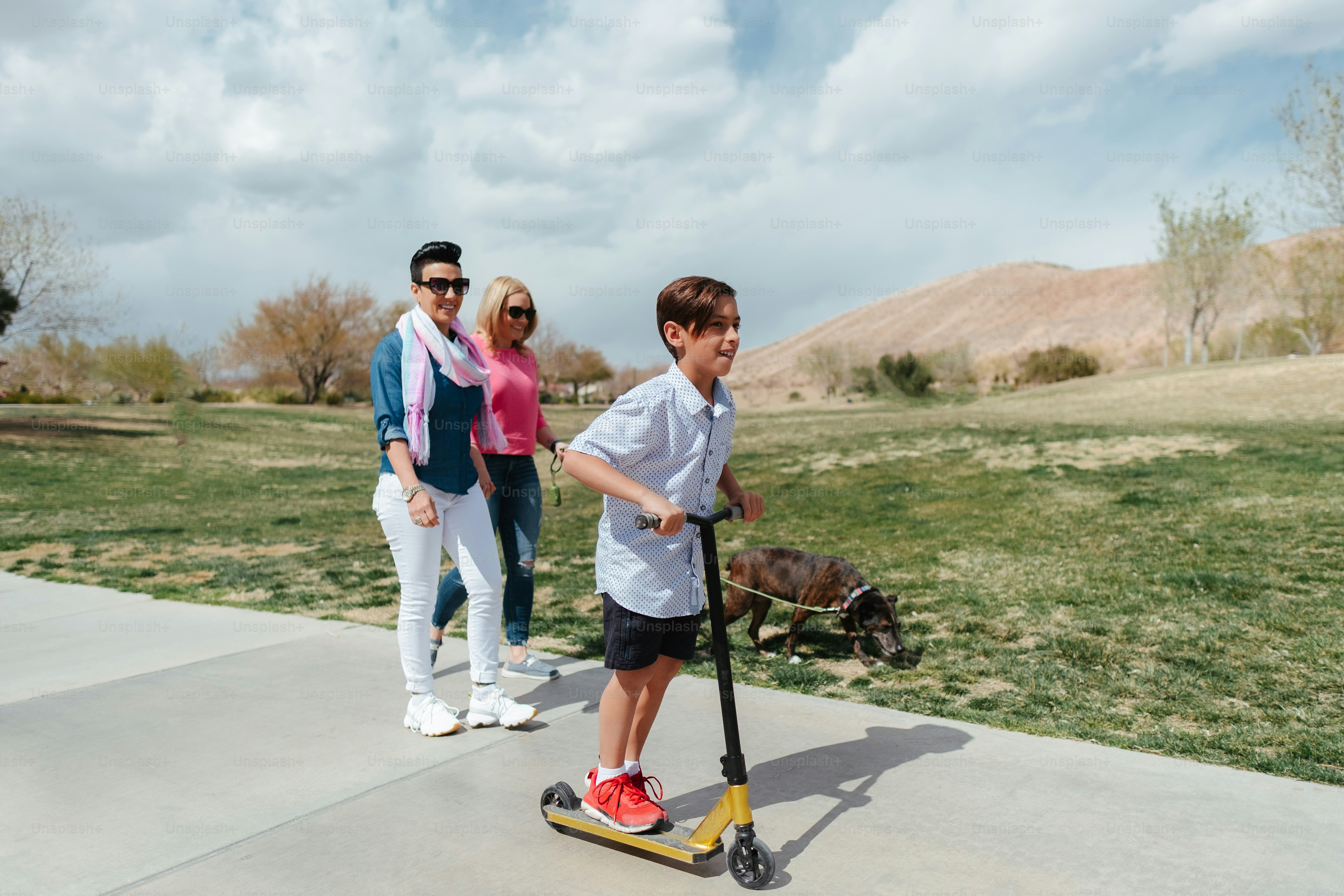 Foto Un niño montando un scooter con una mujer detrás de él – Orgullo ...