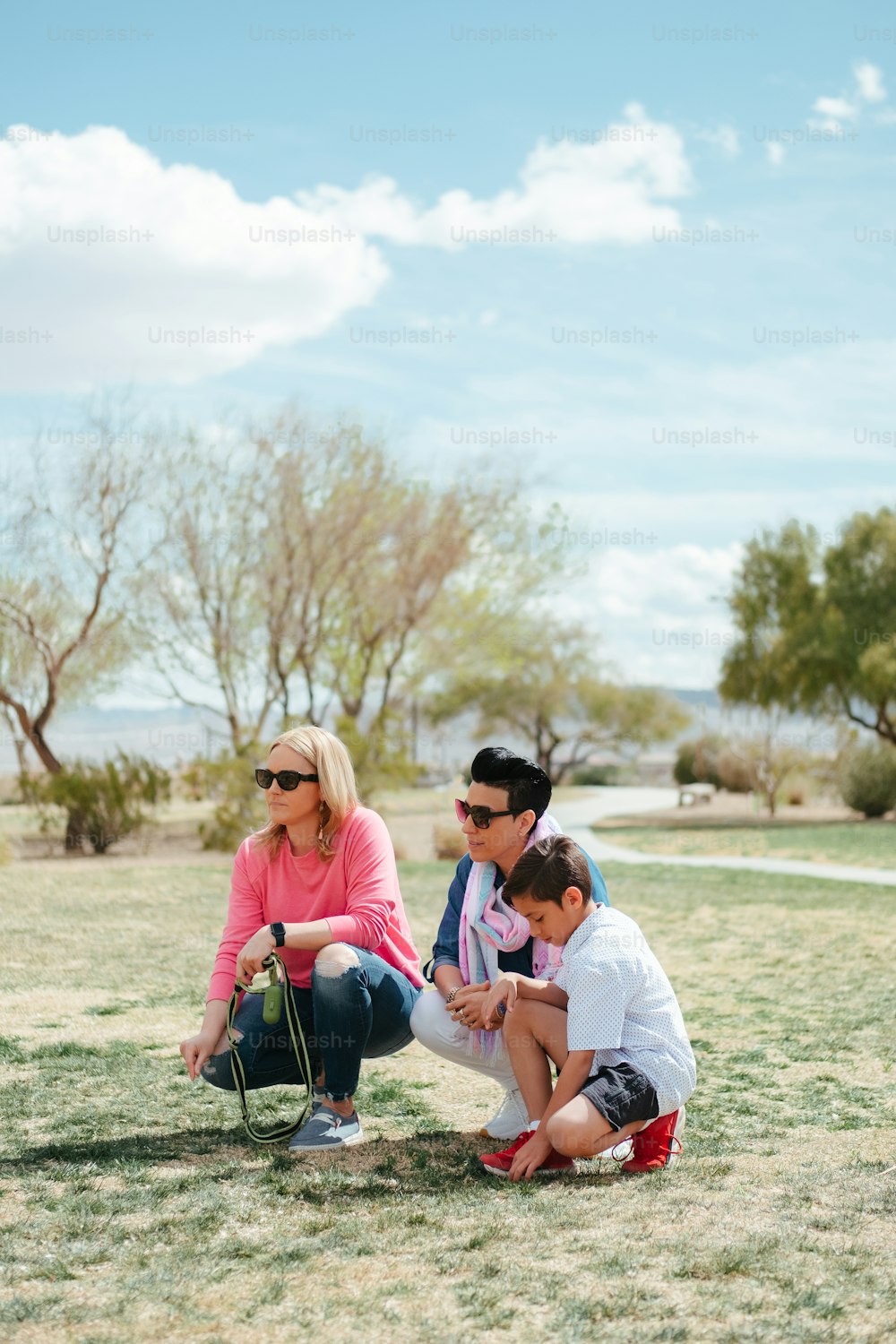 a woman and two children are sitting on a bench