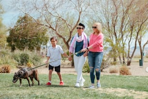 Una familia paseando a su perro en un parque