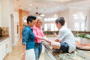 a group of people standing around a kitchen counter