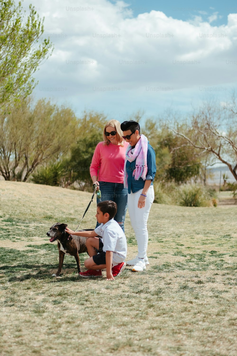 uma mulher e duas crianças com um cão na coleira