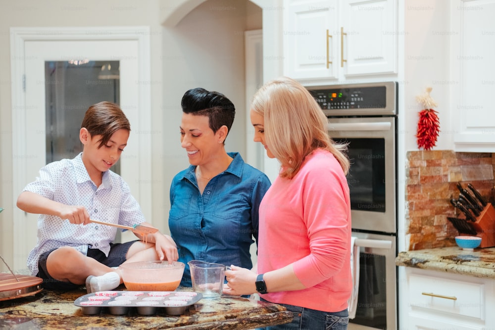 três mulheres e um menino estão preparando comida em uma cozinha
