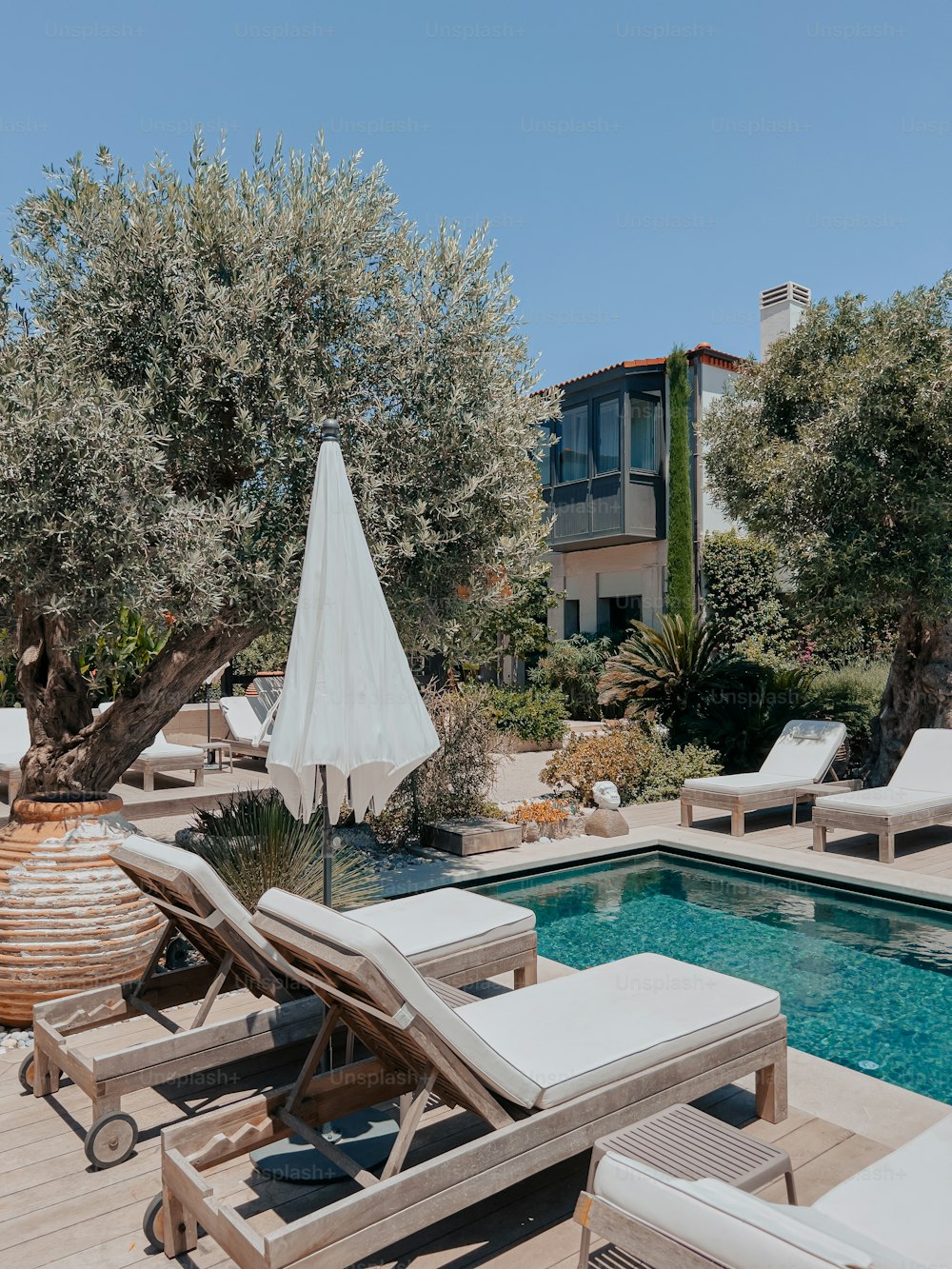 a pool with lounge chairs and an umbrella