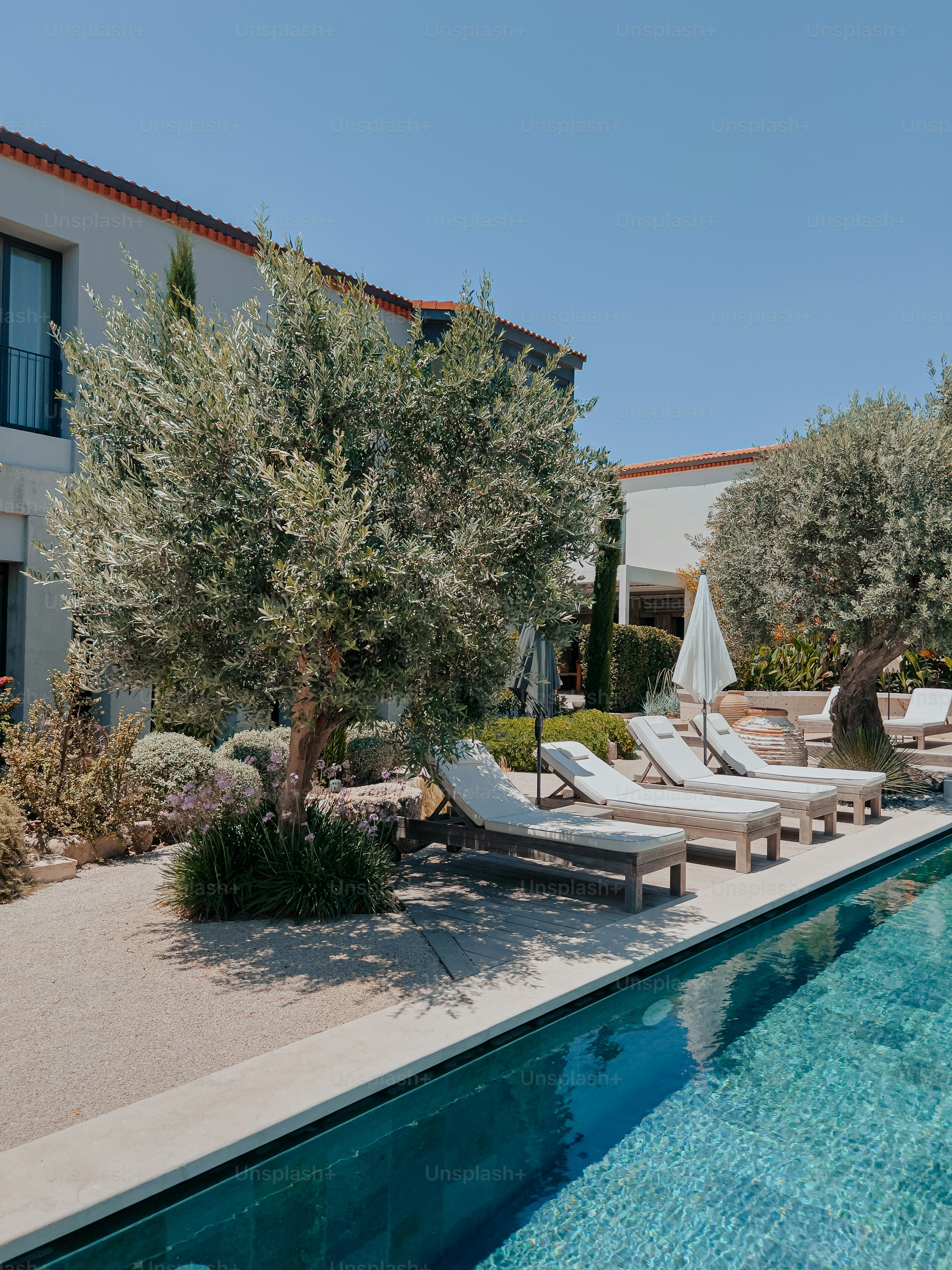 a pool with lounge chairs and an umbrella next to it