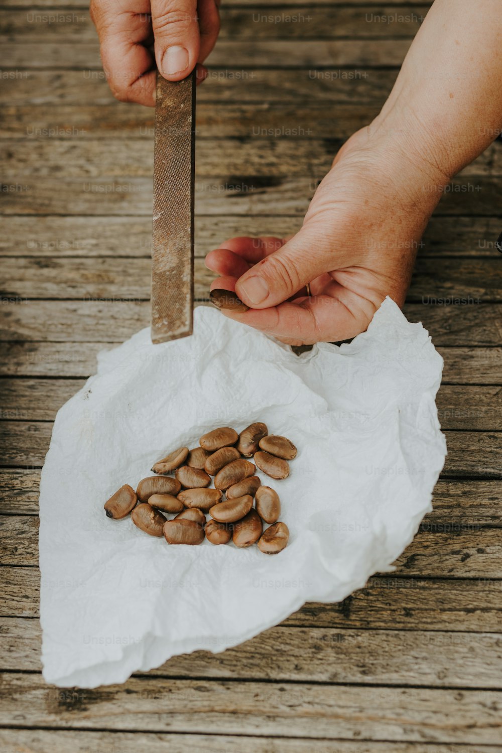 a person cutting almonds on a piece of paper