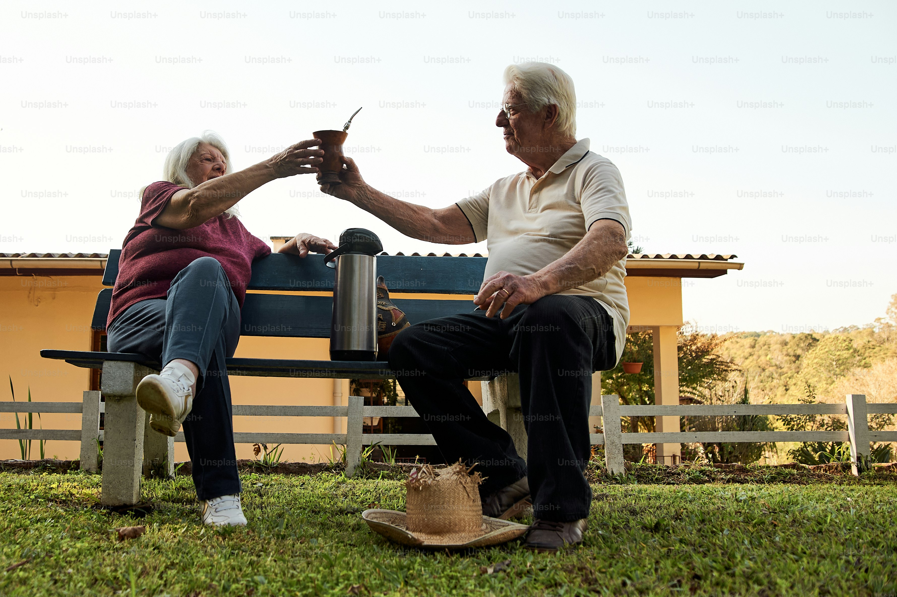 an elderly couple sitting on a park bench