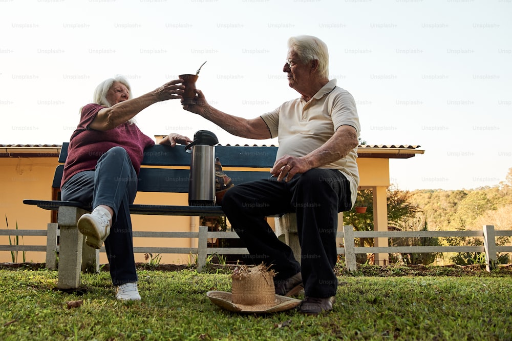 an elderly couple sitting on a park bench
