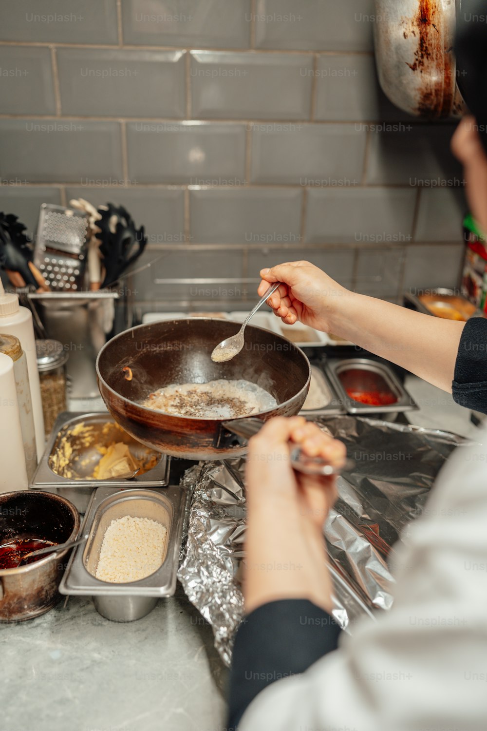 Une femme cuit de la nourriture dans une casserole sur le dessus d’une cuisinière