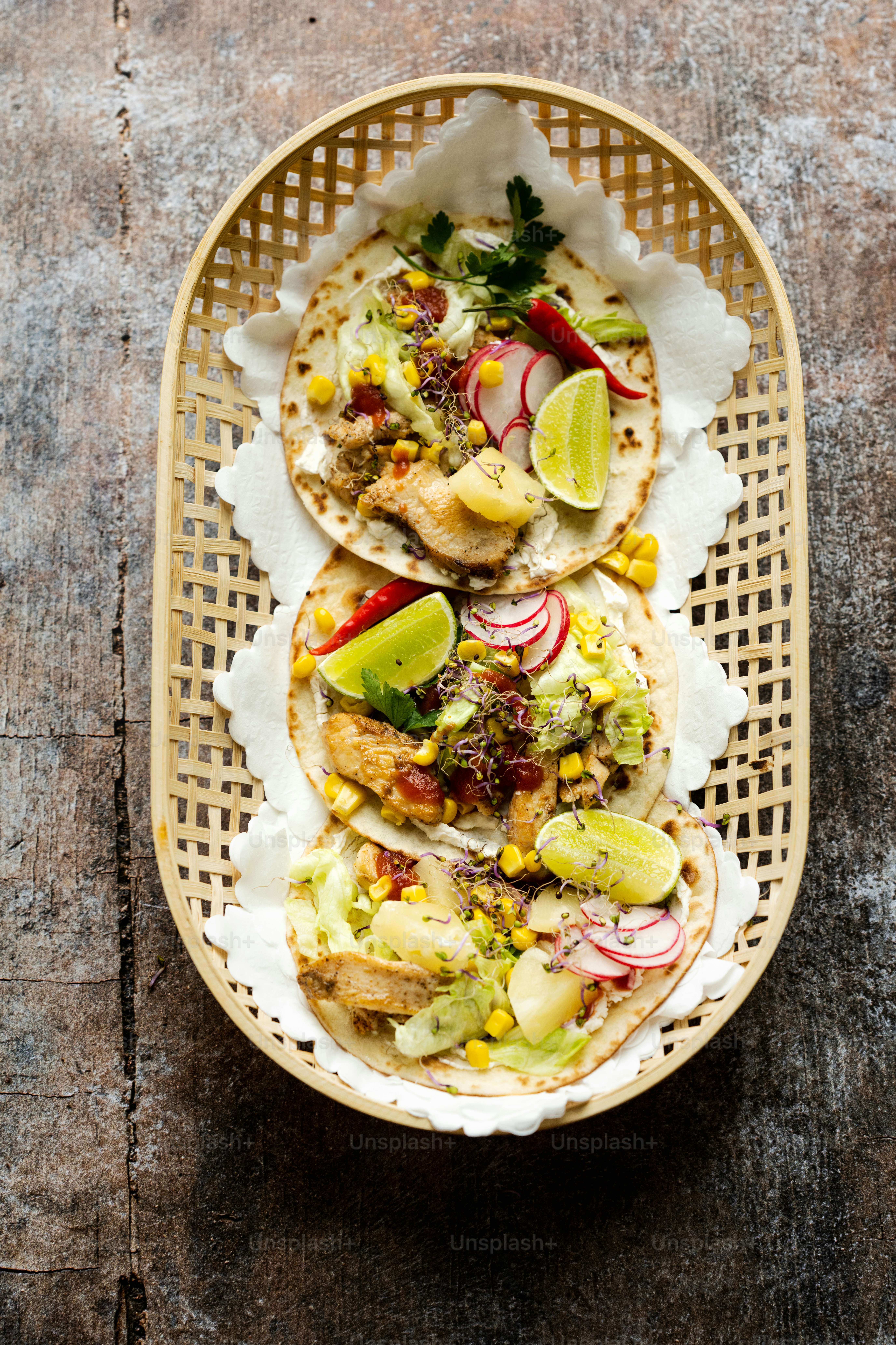 two tacos on a basket on a wooden table