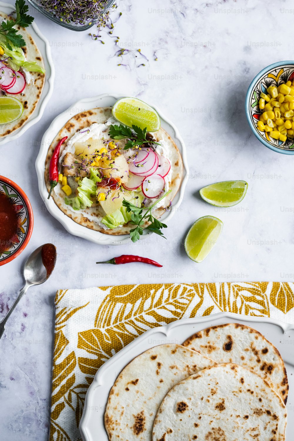 a table topped with plates of food and a bowl of salsa