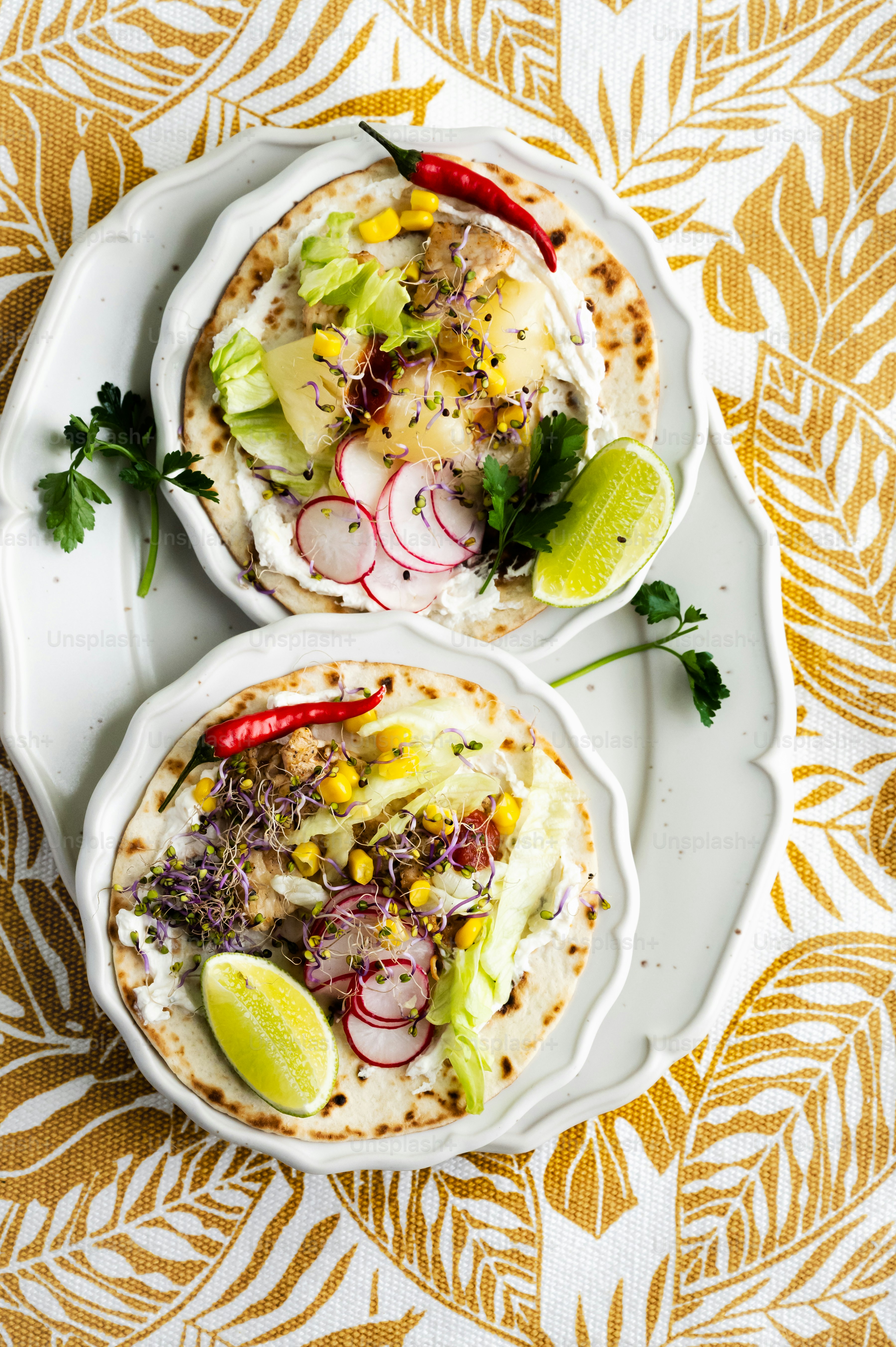 two white plates topped with food on top of a table