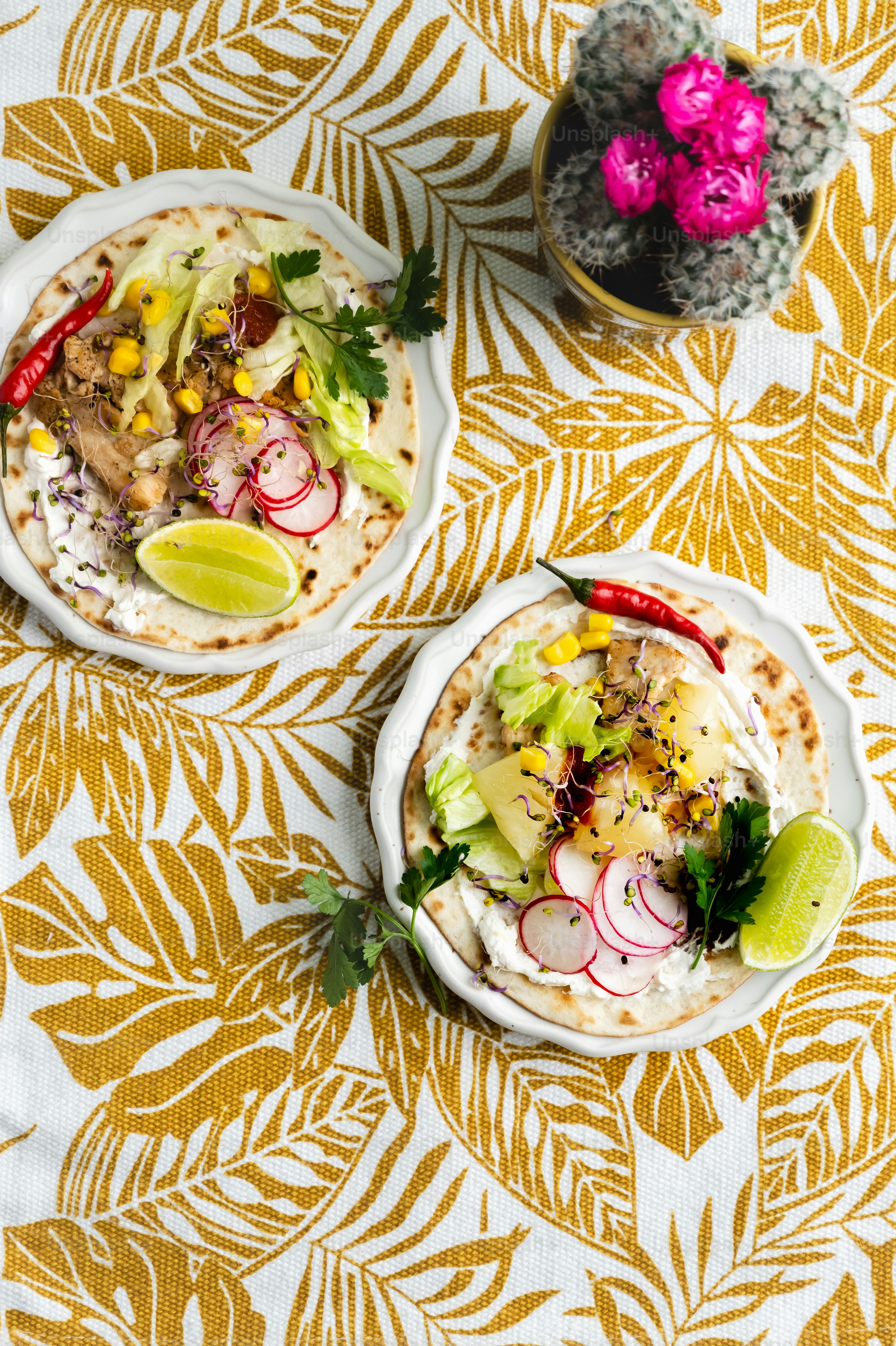 two plates of food on a yellow and white tablecloth