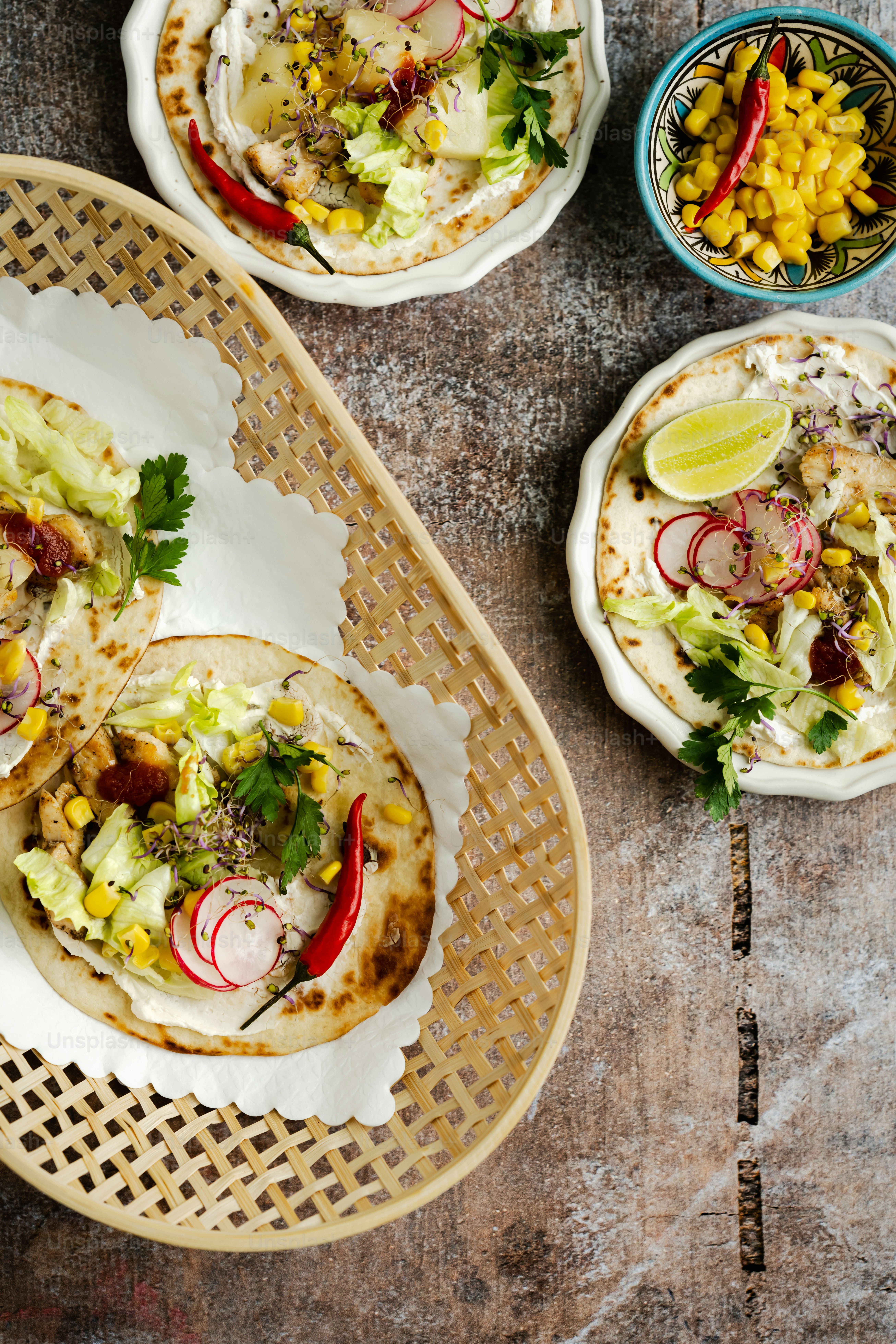 a table topped with three tacos covered in toppings