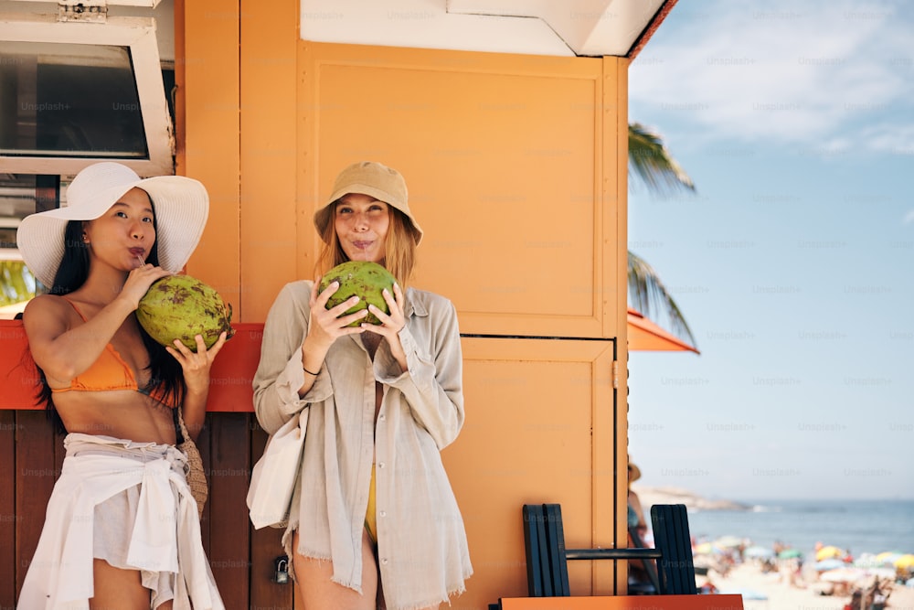 two women standing next to each other on a beach